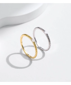 Detail of s925 silver hammered rings in gold and silver finish with zircon stone
