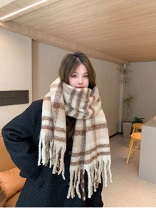 Close-up of brown and beige plaid pattern scarf with soft fringe tassels detail