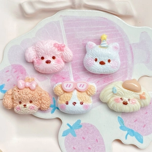 Close-up of five resin cartoon puppy charms with cute hats and bows on a tray