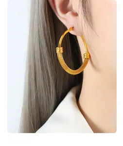 Detail of 18K gold plated hoop earrings featuring a mesh woven design for women