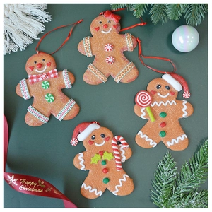 Close-up of four gingerbread man ornaments with glitter texture and red hanging strings