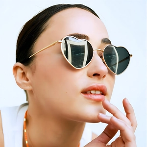 Occhiali da sole alla moda a forma di cuore con montatura dorata e lenti scure