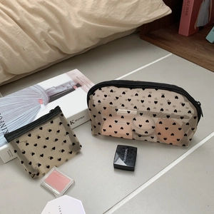 Detailed set of two heart print mesh makeup bags with zippers on tiled floor