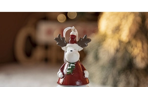 Close-up of a festive reindeer bell ornament hanging on a Christmas tree with warm lights