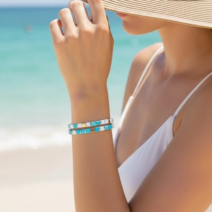 Detail of bohemian Tila bead bracelets in blue, white and gold on a model wrist