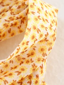 Dettaglio ravvicinato di un tessuto leggero con stampa floreale di girasole e trama fine