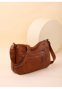 Close-up of soft brown leather texture and functional multi-pocket zipper detail
