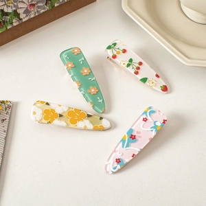 Set of four pastel acrylic hair clips featuring delicate floral and berry patterns