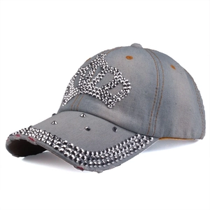 Detailed macro view of silver stud crown motif and rivets on grey denim baseball cap