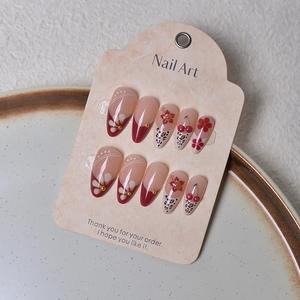 Detail of almond-shaped press-on nails with 3D cherries, leopard print and floral art