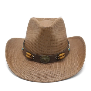 Dettaglio cappello cowboy in paglia marrone con cinturino in pelle e stemma testa di toro