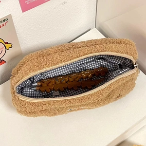 Detail of plush teddy fabric pencil case with checkered lining and cute gingerbread pens