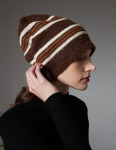 Detailed side view of soft knit striped beanie in brown with white and orange patterns