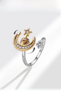 Detailed view of rotating star and moon ring with cubic zirconia on a silver band