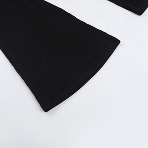 Detailed close-up of the flared hem and stitching on these black backless knit jumpsuits