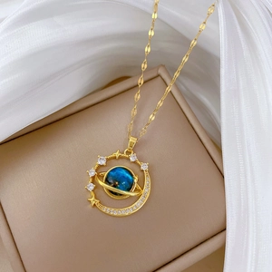 Close-up of golden star and blue planet necklace with shimmering crystals on silk fabric