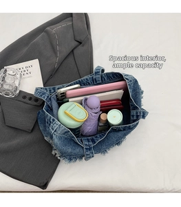 Vue détaillée d'un sac cabas en jean montrant l'intérieur spacieux avec tablette et accessoires