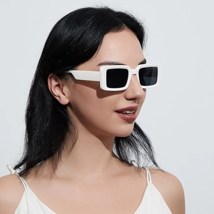 Retro white rectangle sunglasses with dark lenses worn by a model in a side view