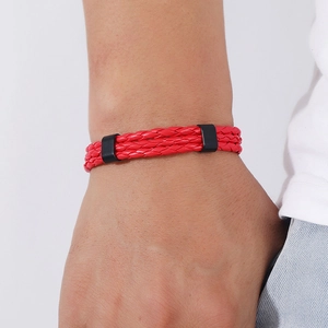 Close-up of a red multilayer braided leather bracelet with black clasp on a wrist