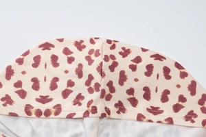 Detailed close-up of leopard print hooded top fabric and high-quality stitching texture