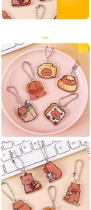 Detailed shot of cute Capybara acrylic keychains with bread and boba tea motifs