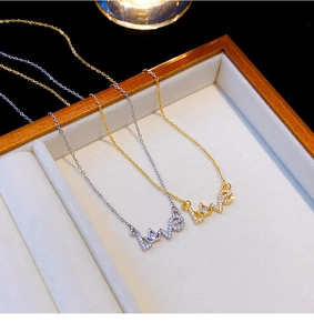 Details von LOVE-Anhängern in Gold und Silber mit Kristallen in einer Geschenkbox