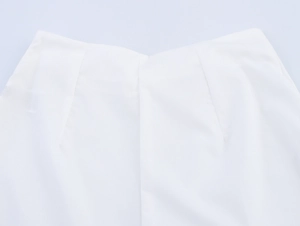 Détail de la taille arrière du pantalon blanc montrant des pinces et un tissu lisse