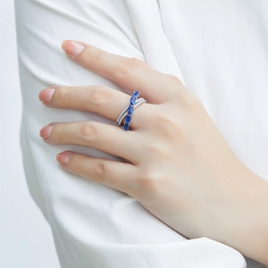 Detail of 925 silver criss-cross ring with oval blue zircon on model's hand
