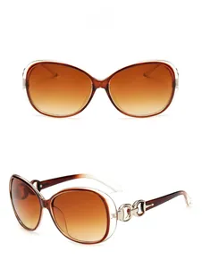 Detail view of large frame sunglasses featuring brown gradient lenses and silver chain arms