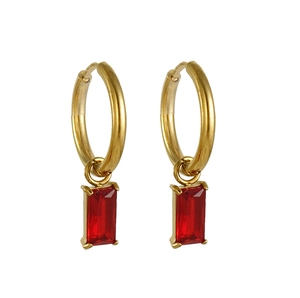 Détail de créoles dorées ornées de pierres de zircon rouge de forme rectangulaire