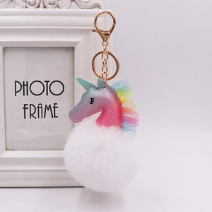 Close-up of unicorn plush keychain with glitter PU leather and white fluffy fur ball charm