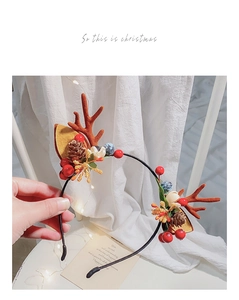 Detail of Christmas reindeer antler headband with festive berries, pine cones and gold leaves