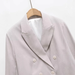 Women's slim-fit short blazer in light grey with double-breasted white buttons