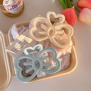 Chic bow hair claws in cream and light blue displayed in a premium gift box setup