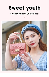 Detailed macro view of pink quilted mini bag featuring pearl handle and gold chain strap