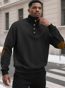 Detail van zwart gewatteerd sweatshirt met opstaande kraag en bruine elleboogstukken