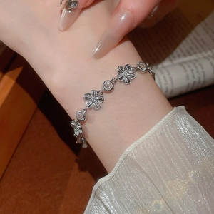 Gros plan d'un bracelet fleur en argent avec zircons étincelants sur le poignet d'une femme