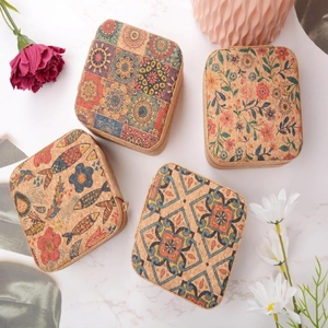 Portable cork jewelry boxes with printed patterns on a marble surface, top view
