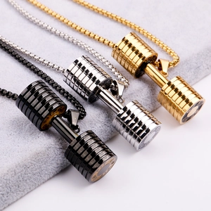 Macro view of dumbbell pendants in gold, silver, and black finishes on box chains