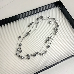 Detailed view of layered gray pearl and silver chain necklace with crystal beads
