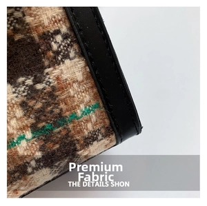 Détail macro du tissu en tweed marron à rayures vertes et bordure en cuir noir