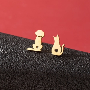 Gold asymmetric pet earrings featuring a hollow heart puppy and kitten on black leather