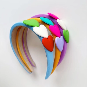 Three colorful sponge headbands with heart charms in blue, yellow, and purple colors