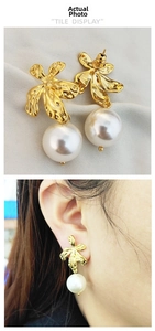 Detail of gold flower earrings with pearls featuring textured metallic finish