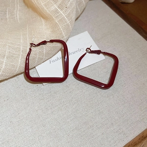 Detail of burgundy red geometric square earrings with a glossy spray paint finish