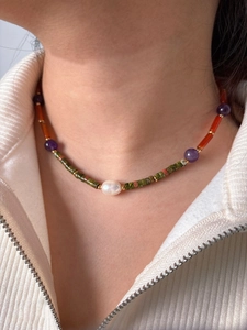Detail of colorful beaded necklace with baroque pearl and natural stones on model