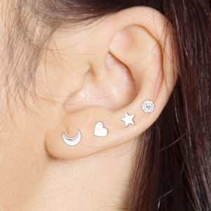 Detail view of crescent moon, heart, and star stud earrings set with cubic zirconia stones