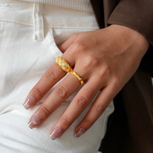 Detail of 24k gold plated geometric ring with quilted texture and pavé zircon stones