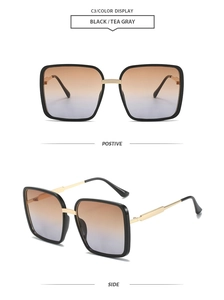 Detalle de gafas de sol cuadradas de gran tamaño con patillas doradas y lentes de gradiente