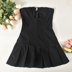 Détail de la robe bustier plissée noire avec une boucle métallique chic sur le corsage